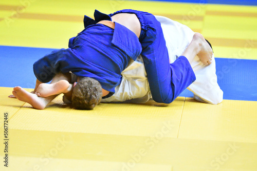 Two Boys judoka in kimono compete on the tatami 