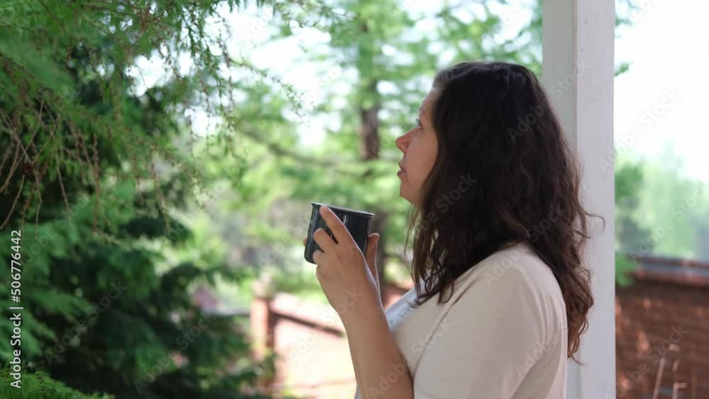 A young woman drinks green tea outdoors. Summer Background. Small depth of field. A young woman drinks green tea outdoors. Summer Background. Small depth of field.