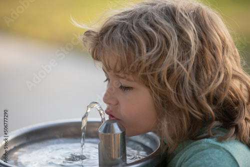 Obraz na plátně Close up portrait of child drinking water from outdoor water fountain outdoor