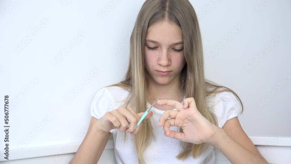 Teenager Girl Cutting Fingernails doing Manicure, Child Cuts Nails Cuticle in Sofa, Adolescent Kid Polishing Nails in Bedroom Teenager Girl Cutting Fingernails doing Manicure, Child Cuts Nails Cuticle in Sofa, Adolescent Kid Polishing Nails in Bedroom