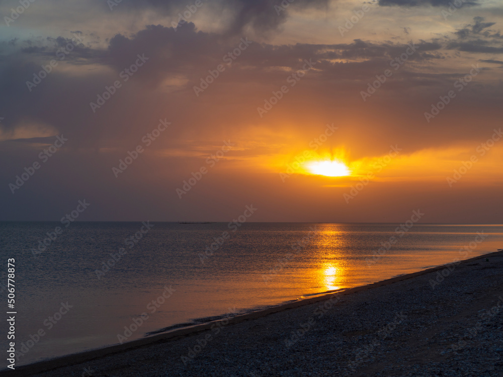 sunset over the sea. Picturesque view of the sea against the background of a colorful sky during sunset with reflection in the water