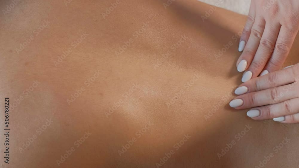 Hands massaging back and shoulders with care Hands massaging back and shoulders with care