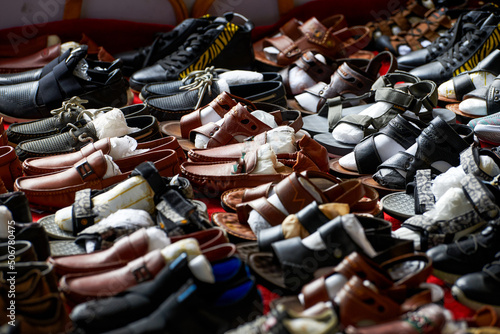 Close-up of a pile of leather shoes for sale at a market stall