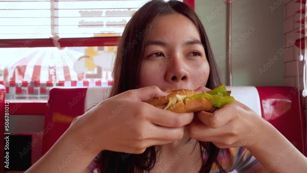 Asian woman eating a burger in a delicious restaurant Asian woman eating 4k junk food lunch Asian woman eating a burger in a delicious restaurant Asian woman eating 4k junk food lunch