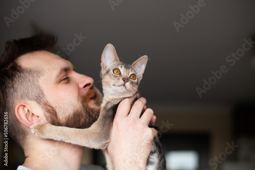 Konstfotografi Close up of bearded man holding his grey cat at home