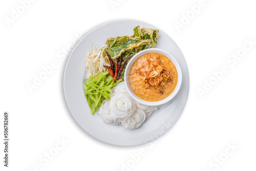Above view of Thai rice noodle with peanut sauce with vegetables in plate isolated on white background. Kanom Jeen Nam Prik of Asian meal traditional style. Popular Thai food. Top-down
