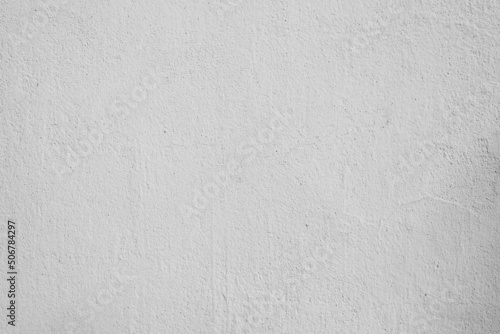 Gray paint plaster with cracks and specks, concrete wall outdoors. Textured rough background