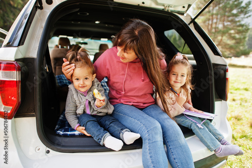 Family at vehicle interior. Mother with her daughters. Children in trunk. Traveling by car in the mountains, atmosphere concept. © AS Photo Family