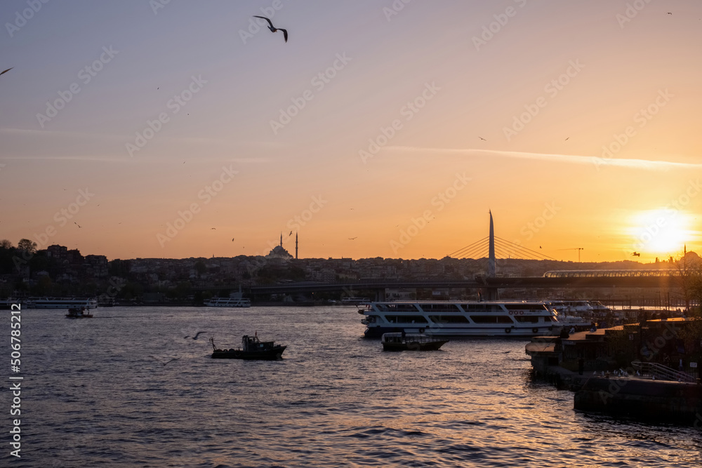 Outstanding yellow sunset of the Turkish sea, flying seagulls and boats swimming across