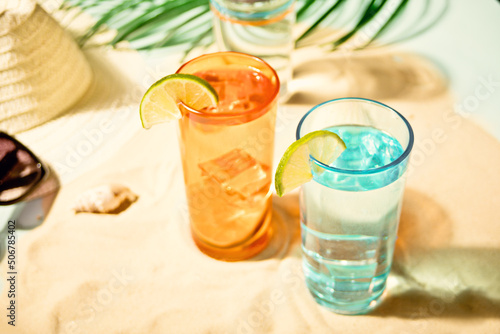 Summer alcoholic cocktails in colorful glasses on beach with white sand. Summer sea ocean vacation and travel concept