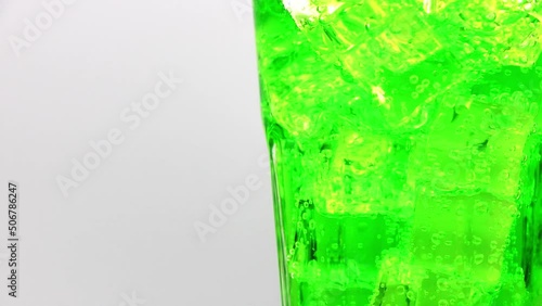 Green sparkling water with Ice in glass. Green sparkling water drink over white background.