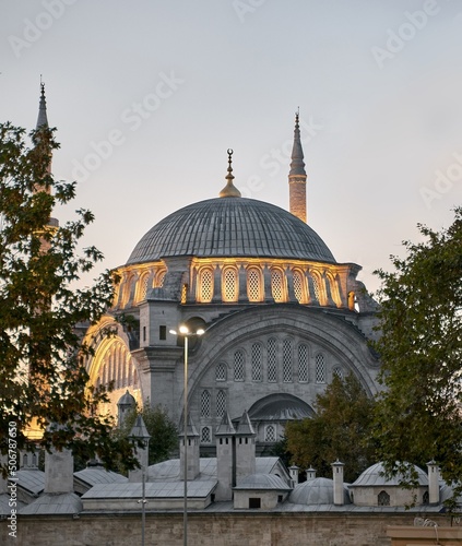 Istanbul cityscape - panoramic view of Suleymaniye Mosque in the evening with light. Traditional arabic town with silhouettes of minarets on sunset, ancient landmarks of muslim architecture in Turkey.