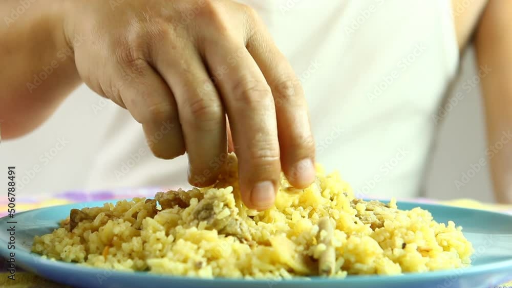 Man is scooping Biryani rice by hand, in studio Chiangmai Thailand Man is scooping Biryani rice by hand, in studio Chiangmai Thailand