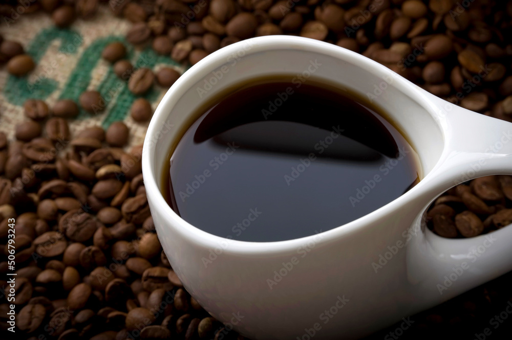 Fototapeta premium Cup of Coffee on Burlap with Dramatic Lighting