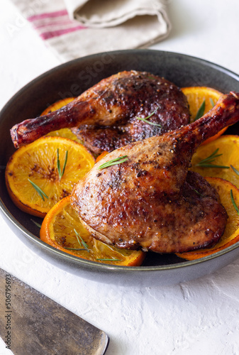 Baked duck legs with oranges and rosemary. Rustic style.