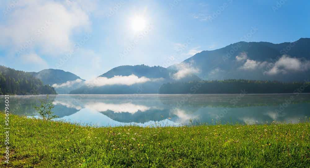 sunrise scenery at lake Sylvenstein, spring meadow with flowers, upper bavaria