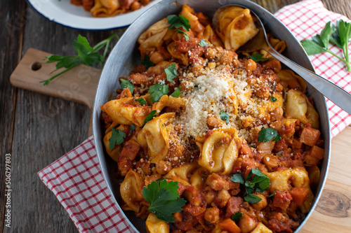 Pasta with tomato sauce, chick peas, pancetta and vegetables. Served with parmesan cheese photo