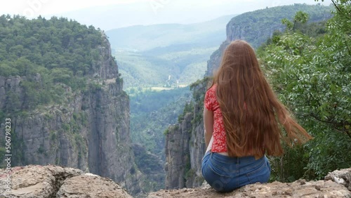 Red hair woman makes photo of Tazi canyon in Turkey. Beautiful landscape with gorgeous canyon with green trees. Young woman spends sunny day in mountains photo