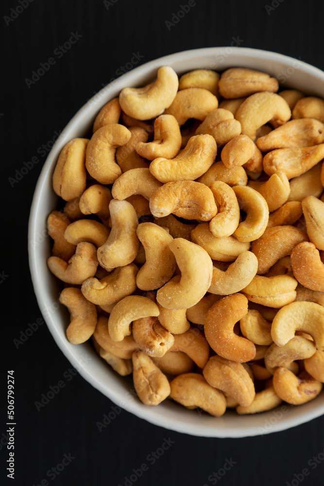 Homemade Roasted and Salted Cashews in a Bowl on a black background, top view. Flat lay, overhead, from above. Homemade Roasted and Salted Cashews in a Bowl on a black background, top view. Flat lay, overhead, from above.