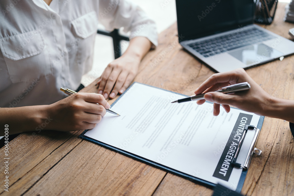 Signing a home loan purchase agreement with a real estate agent. Signing a home loan purchase agreement with a real estate agent.