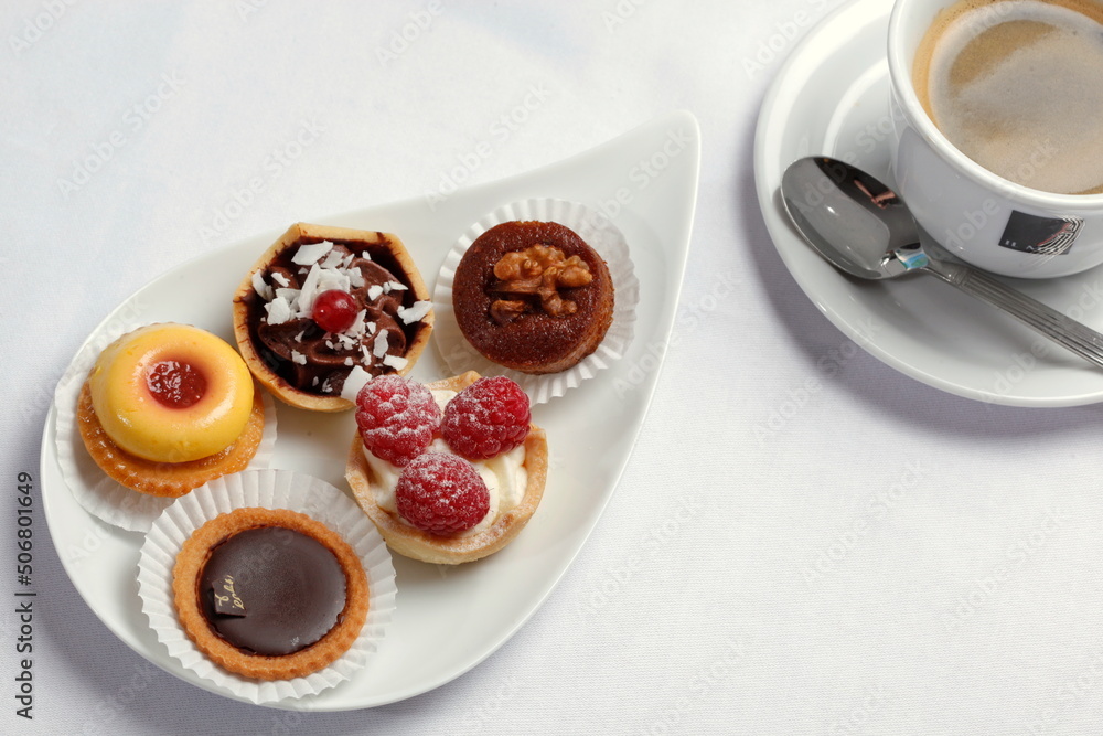 Petits Fours, kleine Kuchen auf Servierplatte, Tasse Kaffee