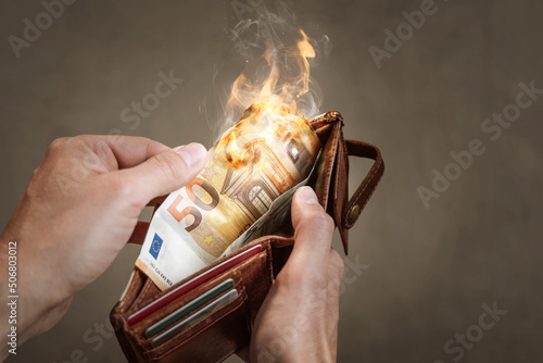 A burning 50 Euro bill in a wallet photo