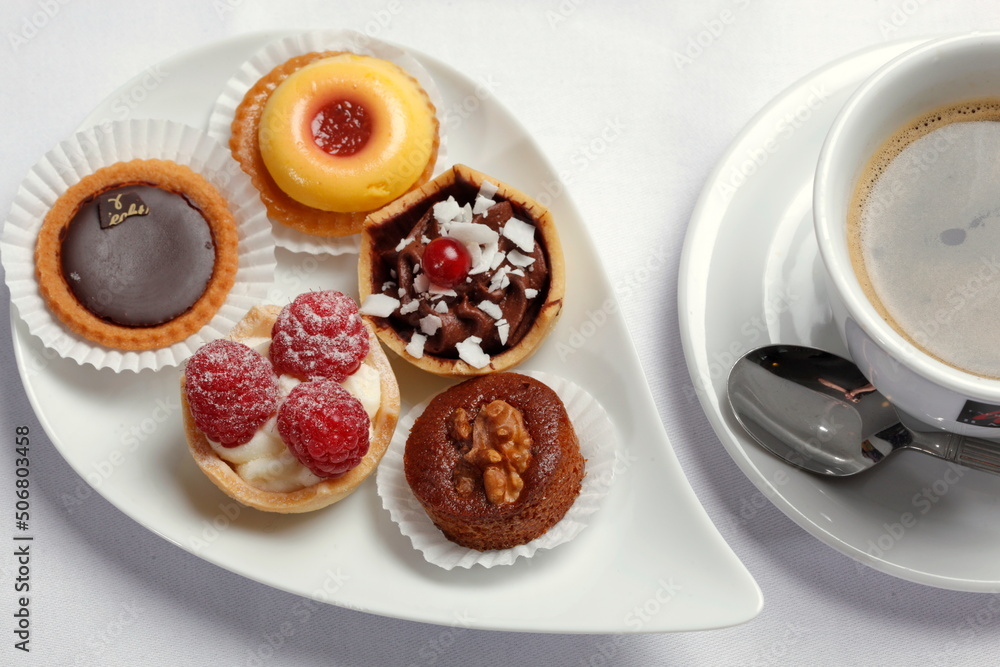 Petits Fours, kleine Kuchen auf Servierplatte, Tasse Kaffee