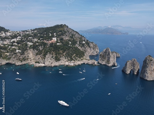 Aerial view of Capri, an island located in the Tyrrhenian Sea off the Sorrento Peninsula, on the south side of the Gulf of Naples in the Campania region of Italy. Drone view of Faraglioni di Capri.