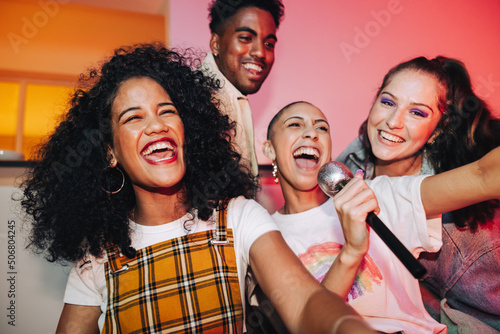Young friends enjoying karaoke night together photo