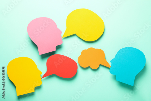 Paper heads with speech bubbles on mint background