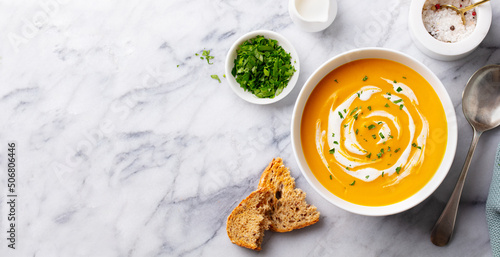 Pumpkin traditional soup with creamy silky texture. Marble background. Copy space. Top view.