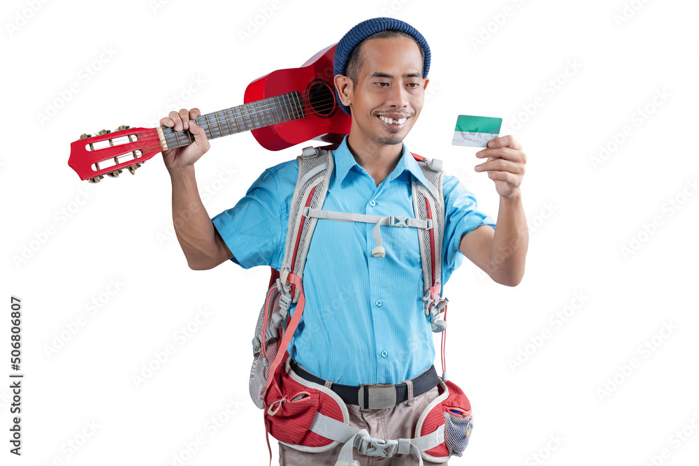 Asian man with a beanie hat and a backpack holding card and carrying a guitar Asian man with a beanie hat and a backpack holding card and carrying a guitar