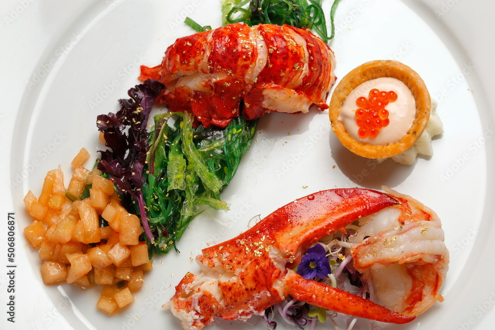 Hummerschere und Hummerschwanz mit Blattgold und Algensalat