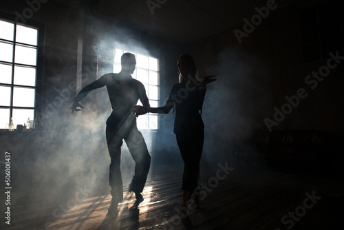 Fotobehang Couple of two professional ballroom dancers is dancing on loft studio