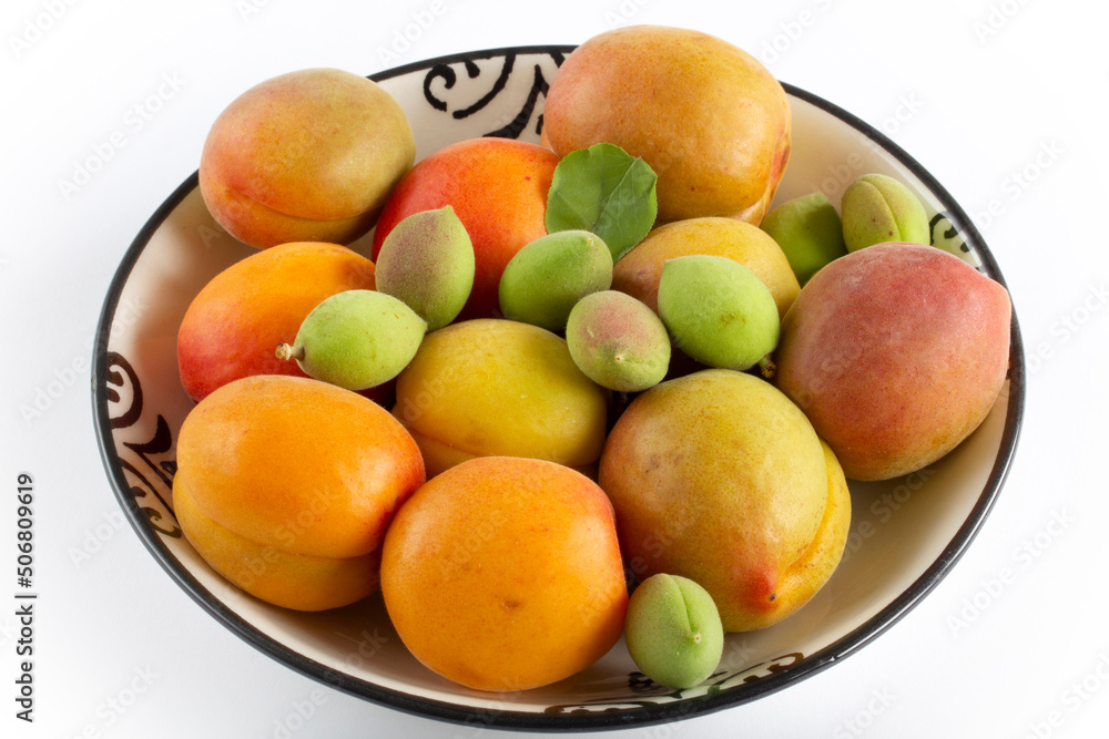 green fresh apricots and ripe apricots in the plate green fresh apricots and ripe apricots in the plate