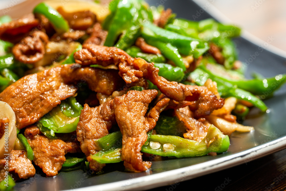 Fototapeta premium A plate of delicious and spicy Hunan dishes, fried pork with chili