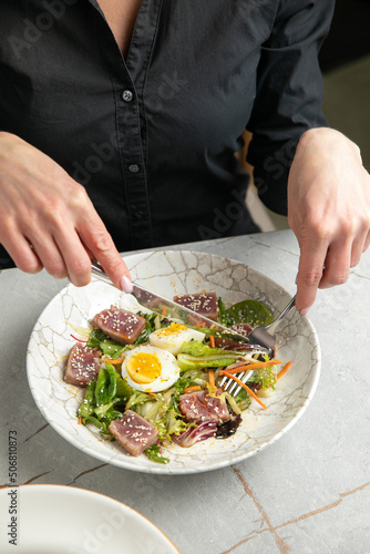 salad with tuna  lettuce  herbs  egg  on a gray table 