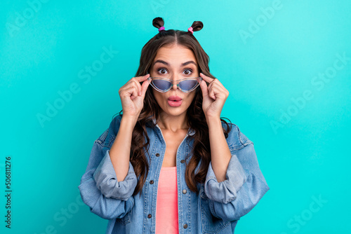 Photo of young lovely girl hands touch glasses unexpected face reaction information isolated over teal color background