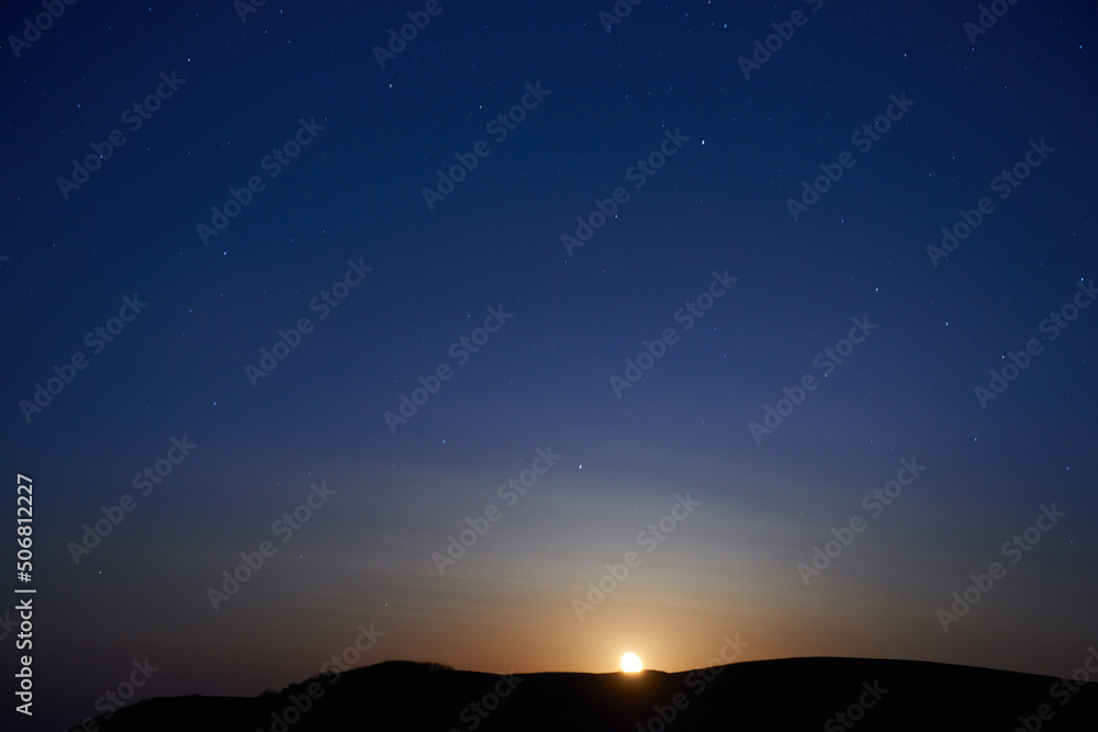 Sunset above mountain and blue dark night sky with stars Sunset above mountain and blue dark night sky with stars