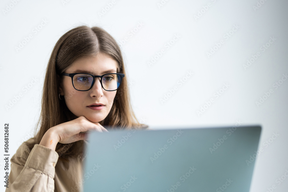 Business woman using laptop computer and sitting by the table in office Business woman using laptop computer and sitting by the table in office