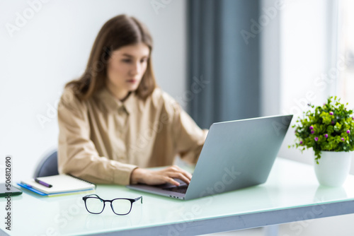 Beautiful business woman is looking at camera and smiling while working in office