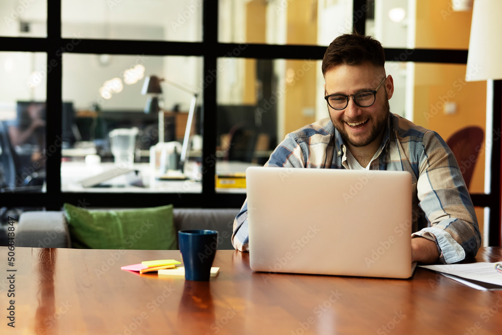 Young businessman using laptop in his office. Handsome man working in the office.. Young businessman using laptop in his office. Handsome man working in the office..