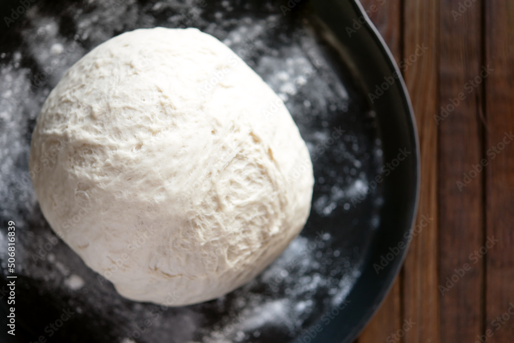 yeast dough for bread or pizza on a floured surface, with flour splash. Cooking bread. yeast dough for bread or pizza on a floured surface, with flour splash. Cooking bread.