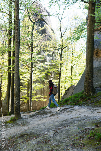 woman hiker with backpack walking by forest trail © phpetrunina14