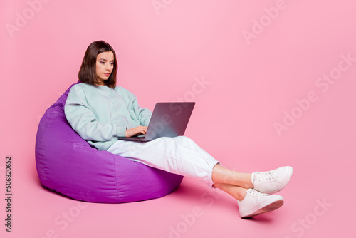 Full size profile photo of strict bob hairstyle millennial lady sit type laptop wear hoodie pants shoes isolated on pink background