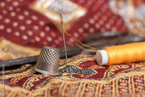 Golden Thread and Thimble on Vintage Fabric From The Middle East photo