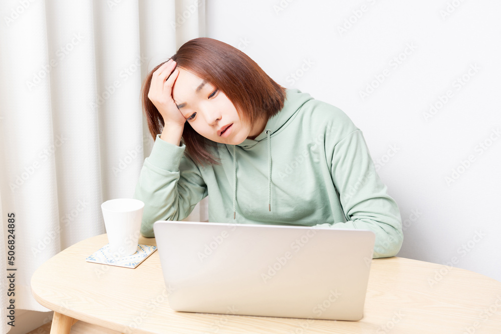 パソコンを使いながら落ち込んでいる女性