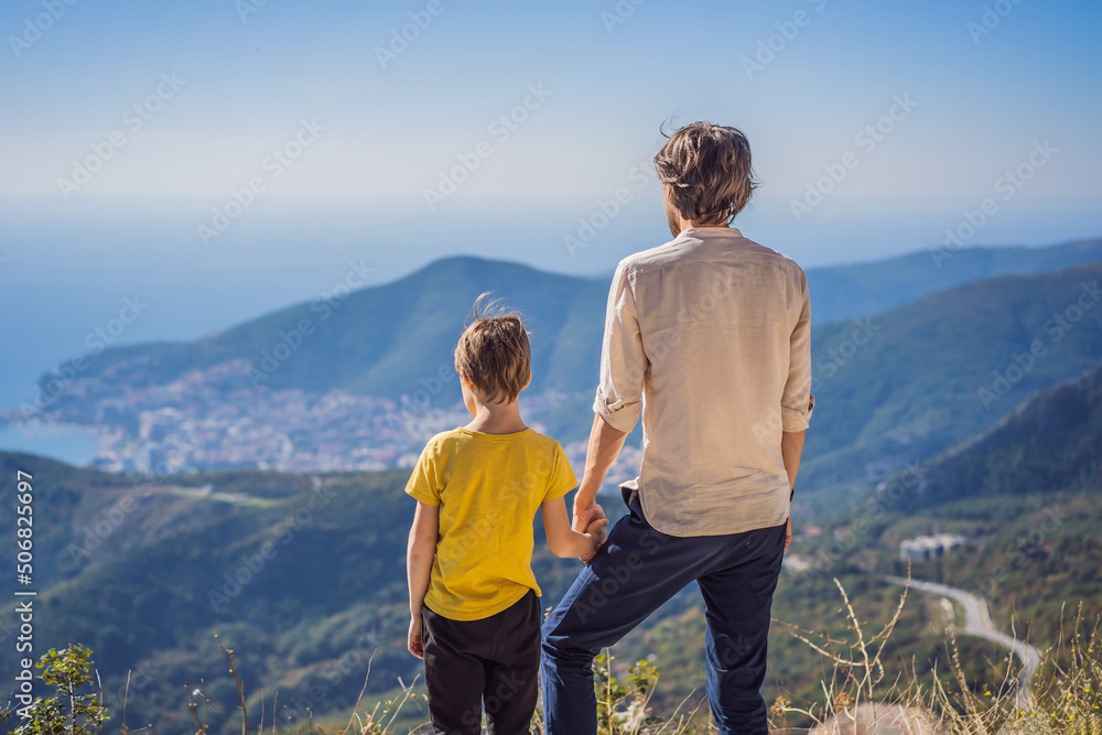 Happy family on the background of Panoramic view of the city of Budva, Montenegro. Beautiful view from the mountains to the Adriatic Sea Happy family on the background of Panoramic view of the city of Budva, Montenegro. Beautiful view from the mountains to the Adriatic Sea