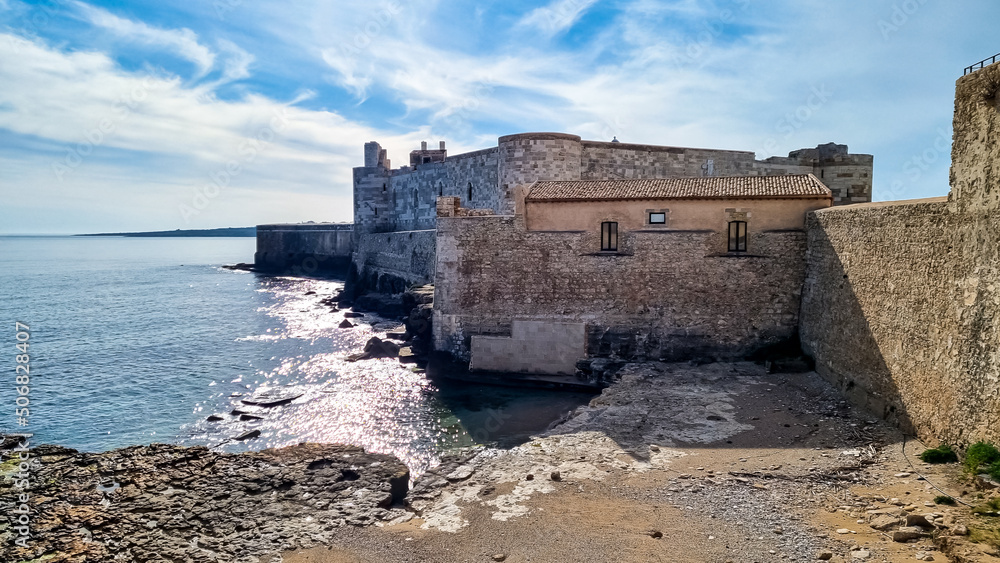 Exterior view of the ancient Maniace Castle (Castello Maniace) on island of Ortygia in Syracuse, Sicily, Italy, Europe EU. Old citadel fortress is UNESCO World Heritage Site. Tourism