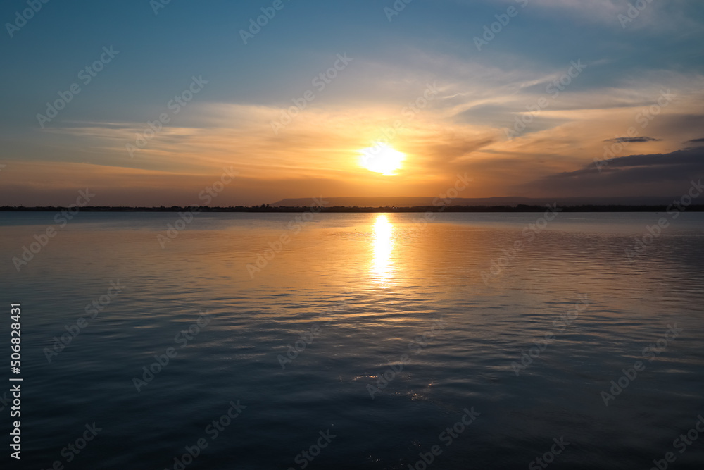 Panoramic view during sunset on the harbor of Ortigia island in the city Syracuse, Sicily, Italy, Europe, EU. Romantic water reflection in the Siracusa bay in the Mediterranean Sea. Vacation seaside